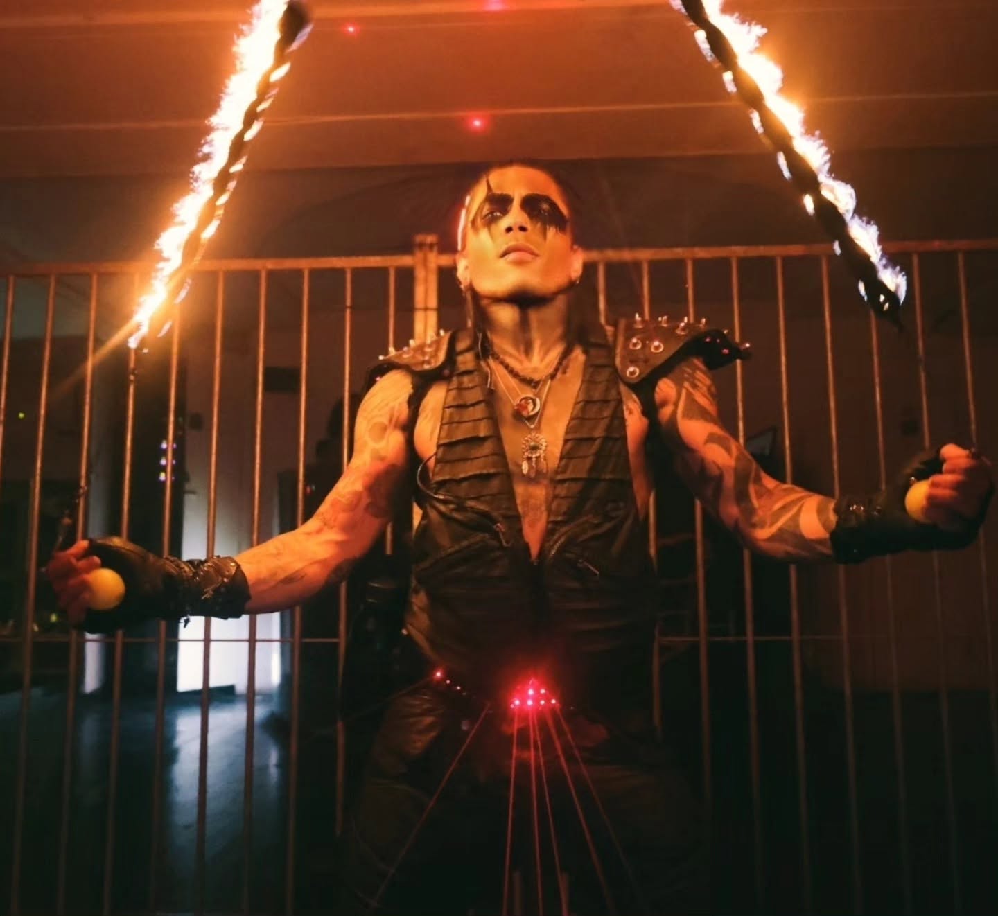 Mike Garcia sous deux accessoires enflammés, lasers rouges sur le costume
